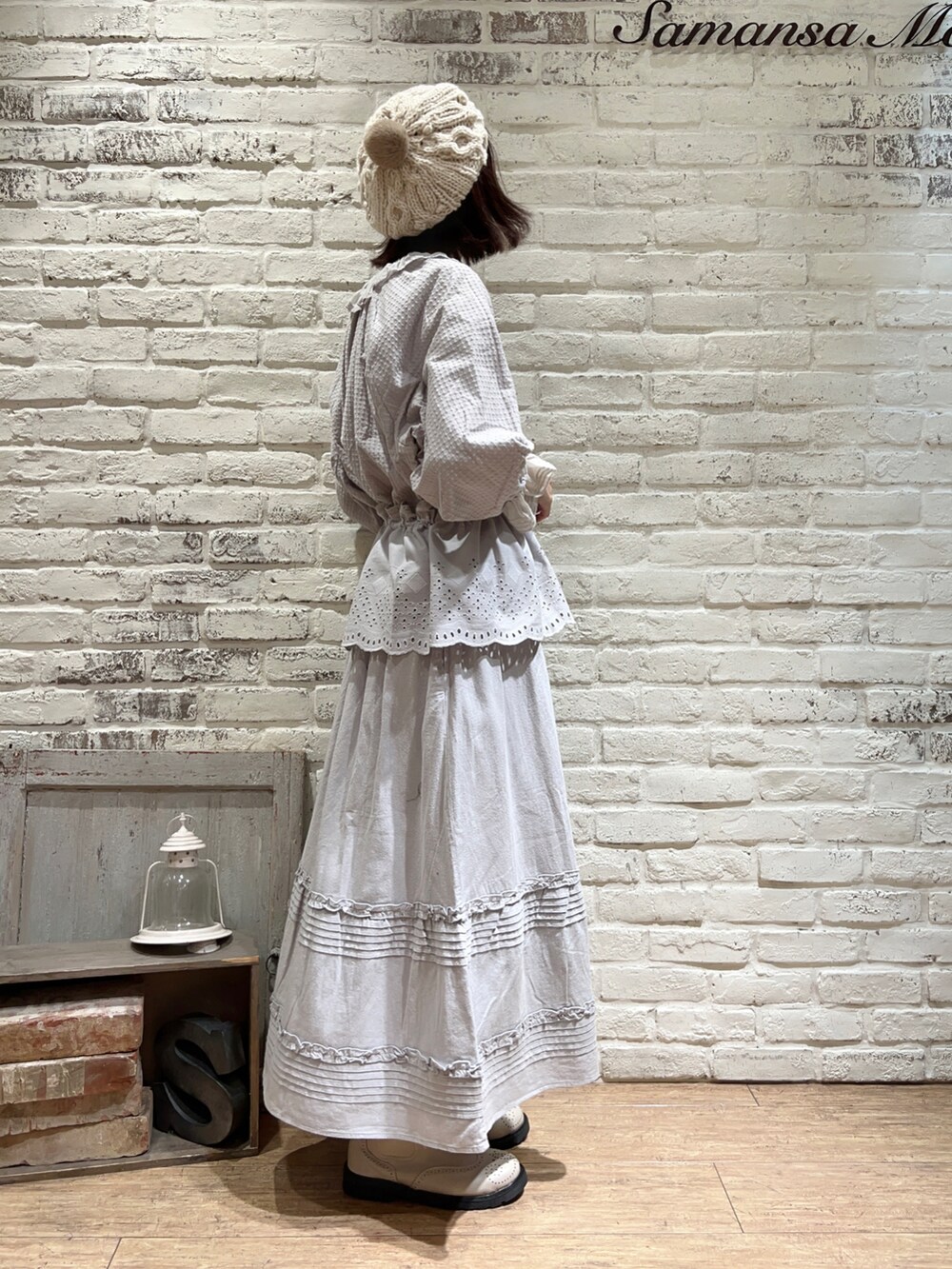 グレー系のシャツ/ブラウス、ブルー系のスカート、ホワイト系のブーツを着用したレディースの冬コーディネートの4枚目の写真