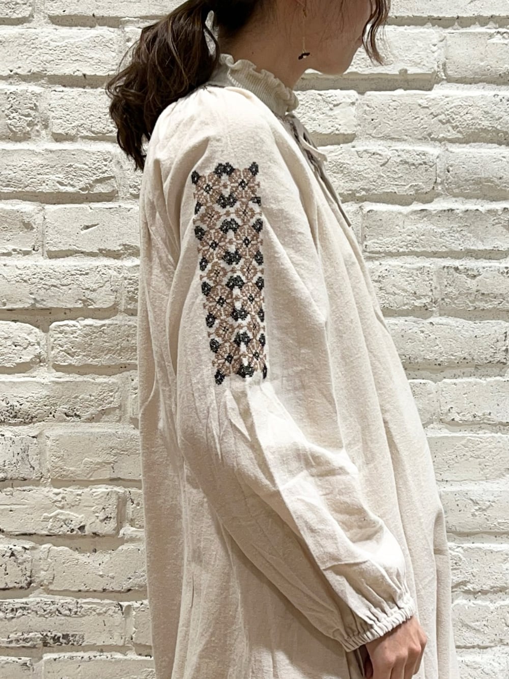 ホワイト系のニット/セーター、ホワイト系のワンピース、ベージュ系のカーディガン/ボレロを着用したレディースの冬コーディネートの3枚目の写真