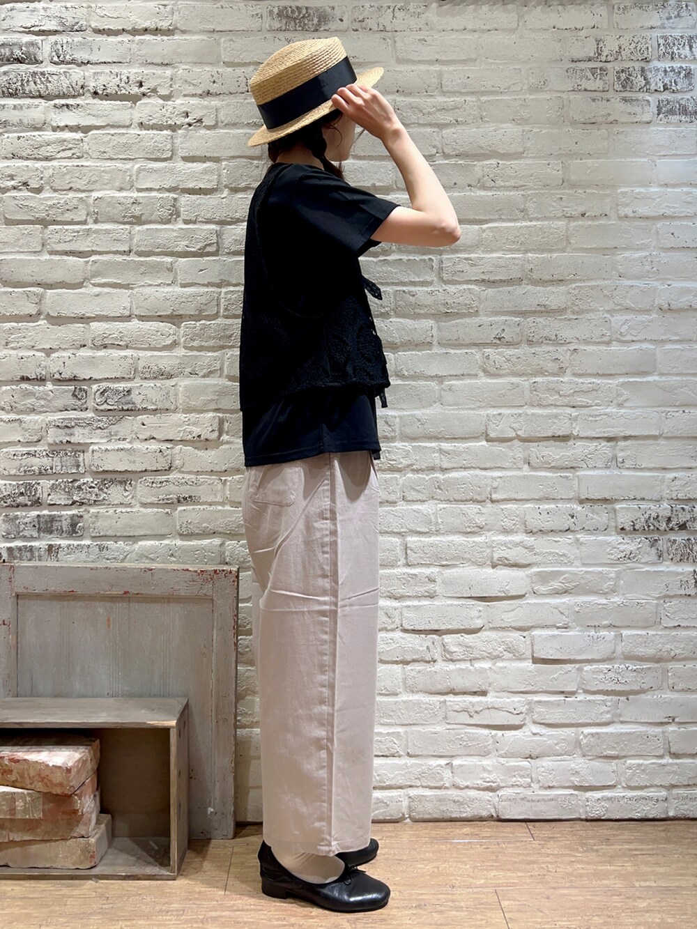 ブラック系のTシャツ/カットソー、ブラック系のベスト、ブラウン系のハンドバッグを着用したレディースの秋コーディネートの3枚目の写真