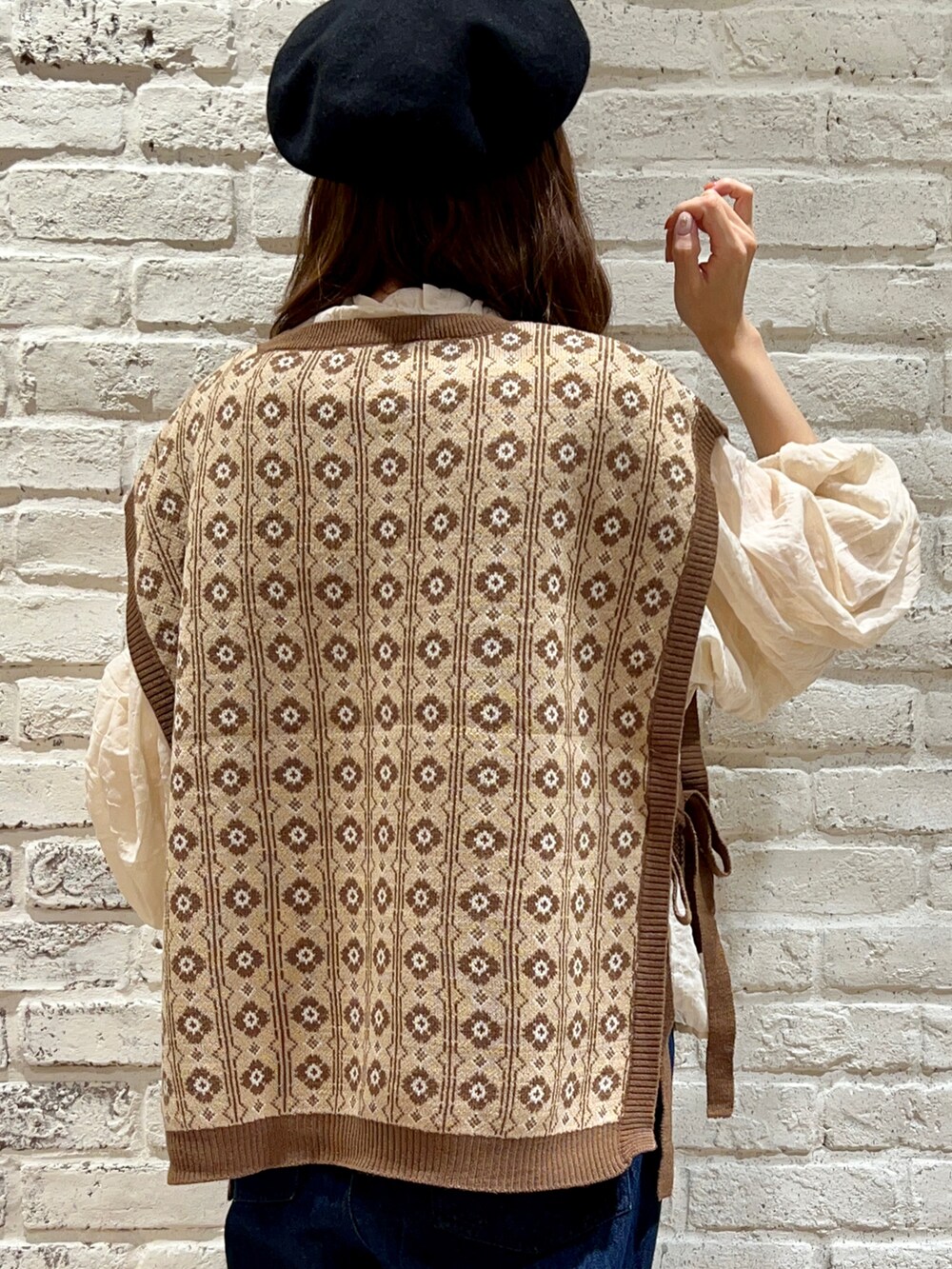 ブラウン系のベスト、ホワイト系のシャツ/ブラウス、ブルー系のデニムパンツを着用したレディースの秋コーディネートの5枚目の写真