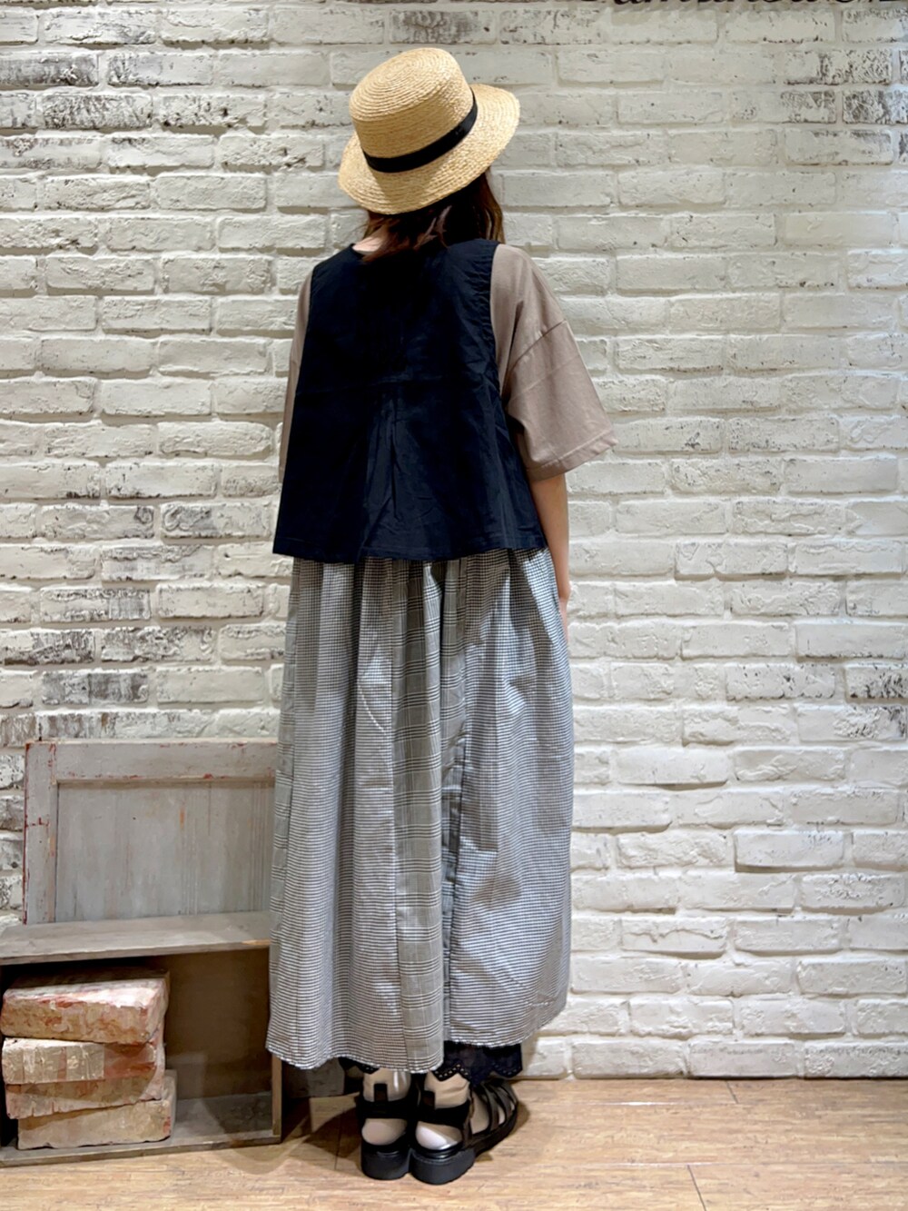 ブラック系のベスト、ブラウン系のワンピース、ブラック系のハットを着用したレディースの秋コーディネートの4枚目の写真