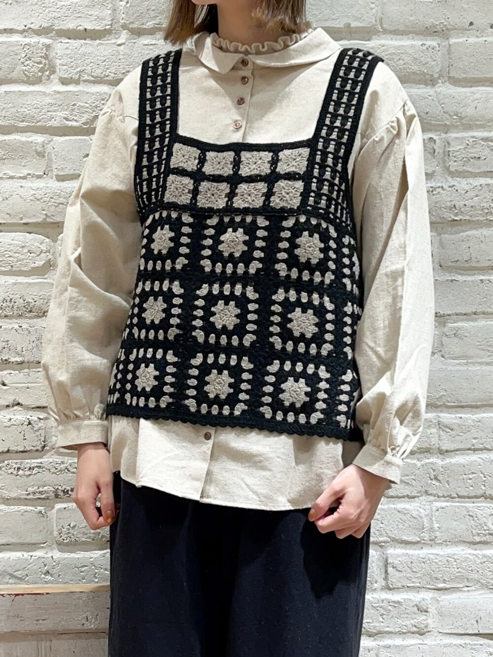 ブラック系のベスト、ホワイト系のシャツ/ブラウス、ブラック系のその他パンツを着用したレディースの冬コーディネートの2枚目の写真