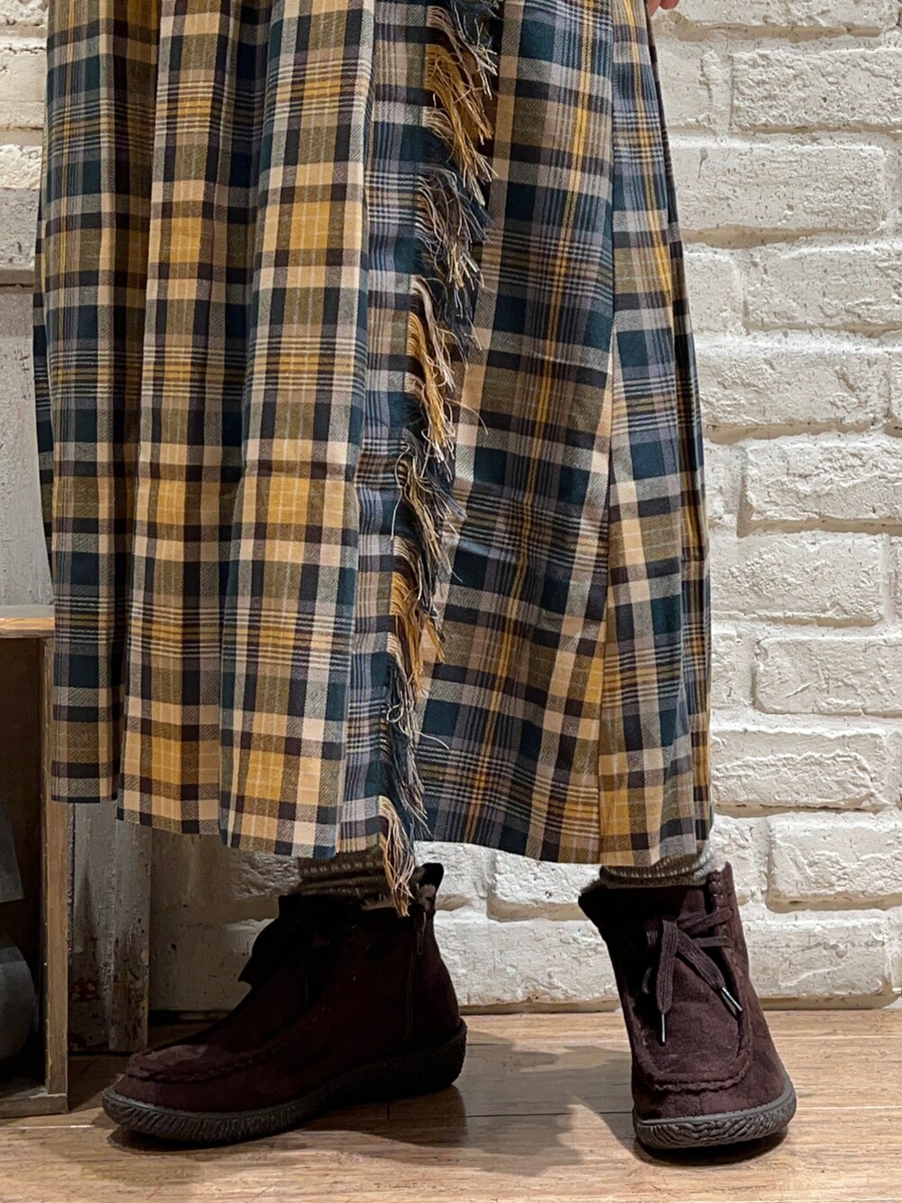 ホワイト系のニット/セーター、ベージュ系のカーディガン/ボレロ、グリーン系のスカートを着用したレディースの冬コーディネートの5枚目の写真