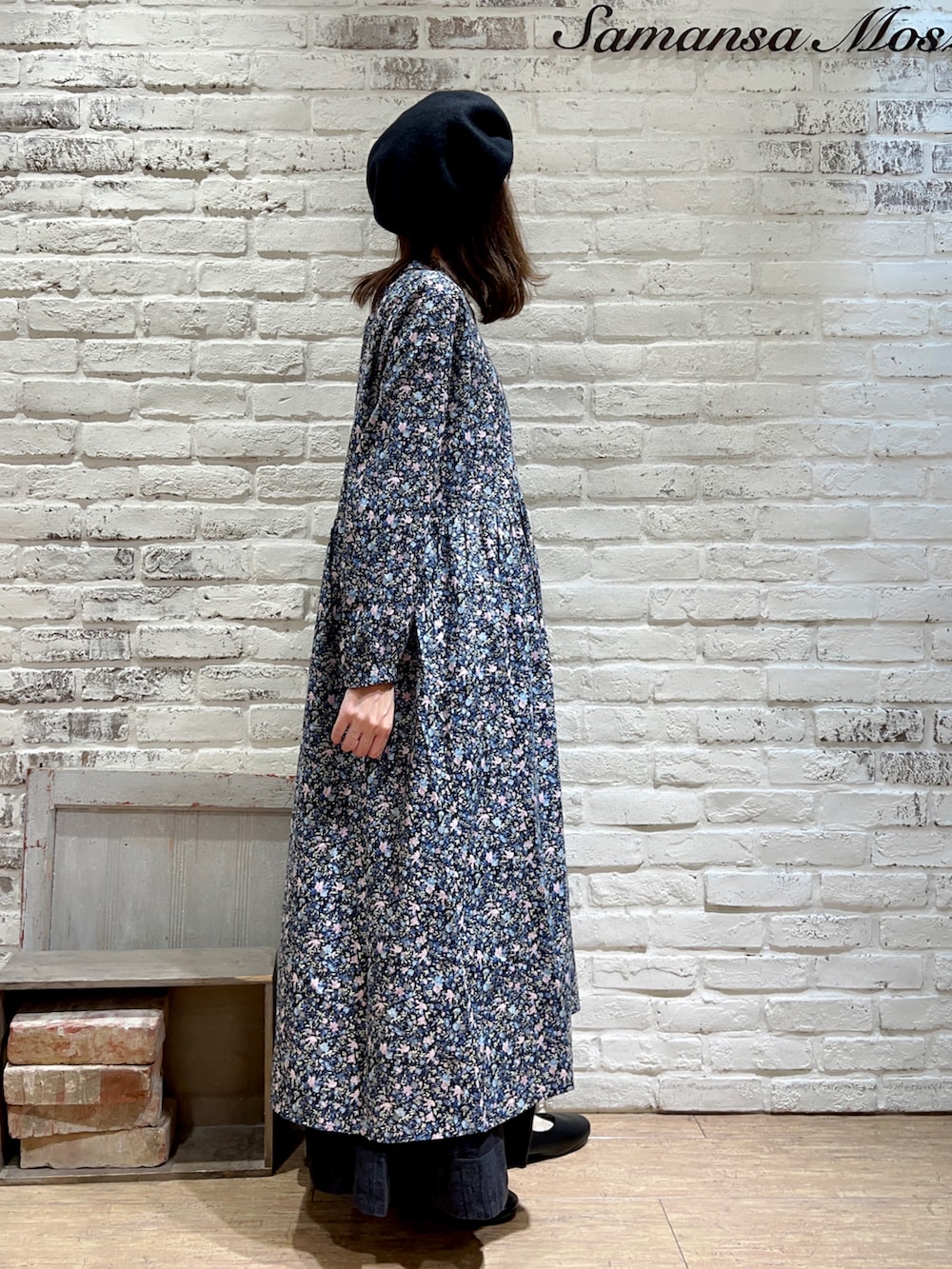 ホワイト系のタンクトップ、ピンク系のワンピース、ブラック系のスカートを着用したレディースの秋コーディネートの3枚目の写真