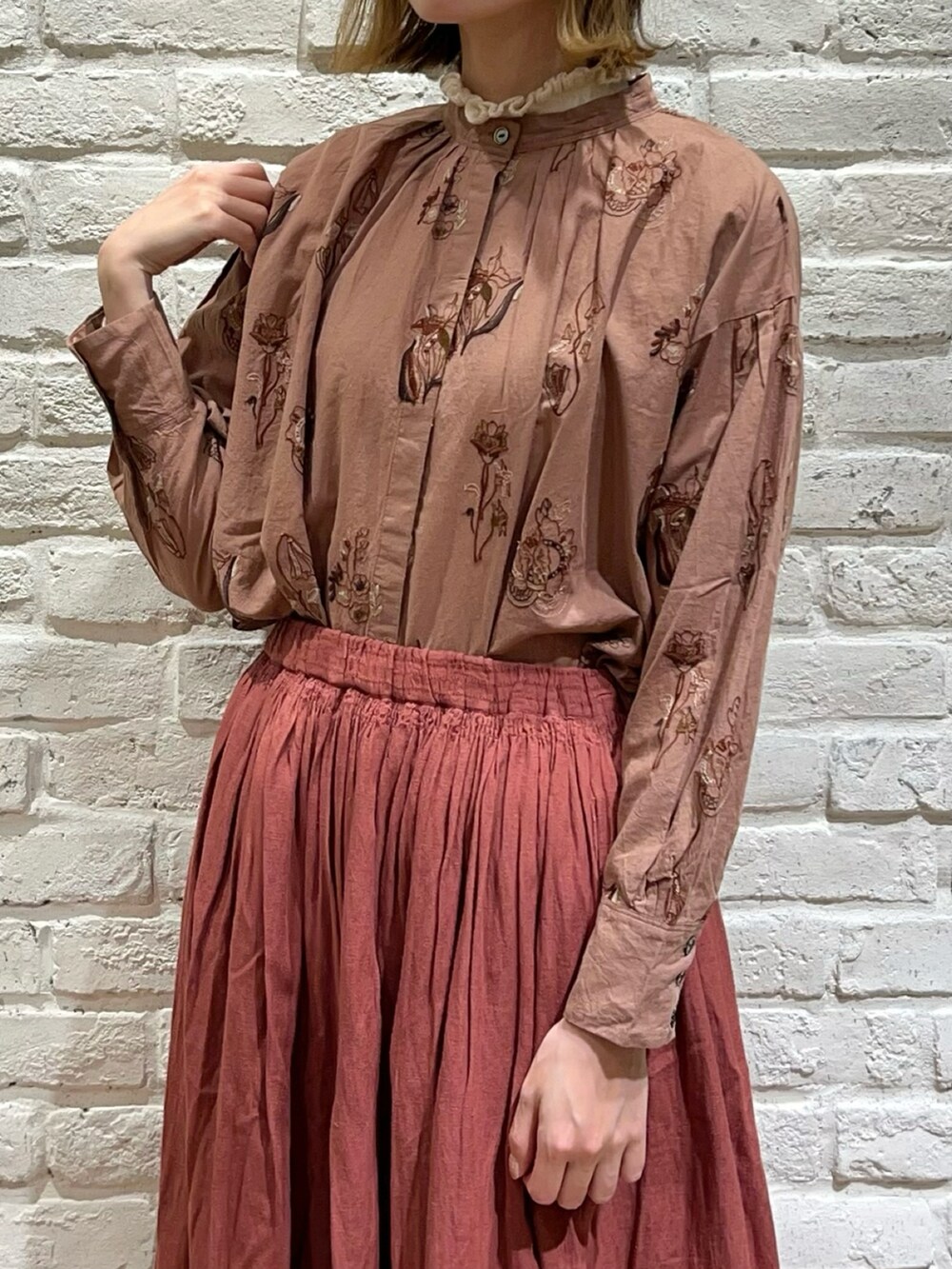 ホワイト系のニット/セーター、ベージュ系のカーディガン/ボレロ、ベージュ系のスカートを着用したレディースの秋コーディネートの3枚目の写真