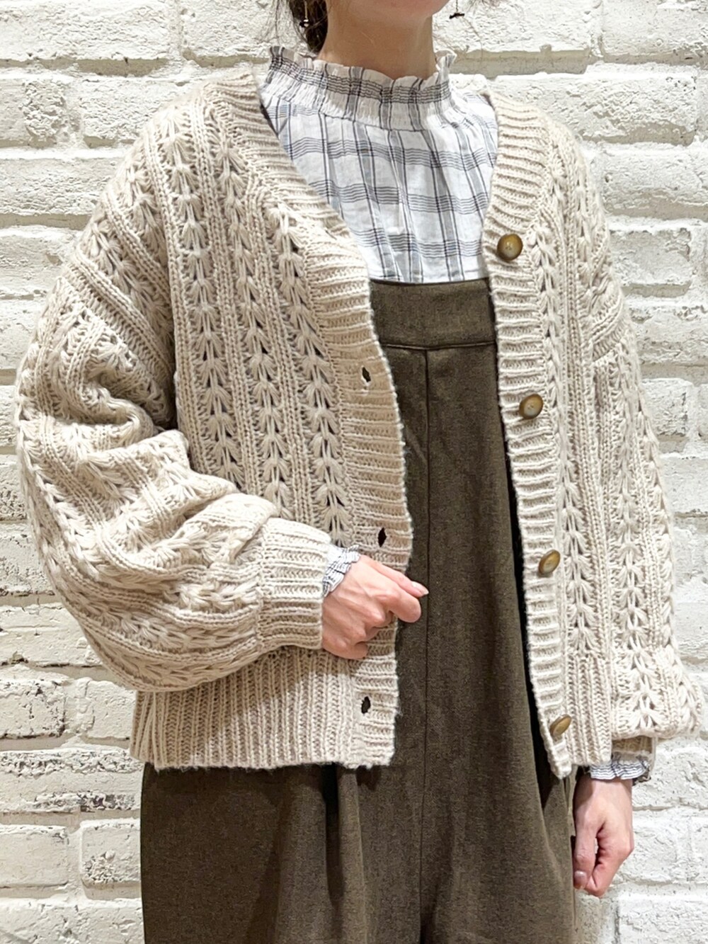 ホワイト系のシャツ/ブラウス、ベージュ系のニット/セーター、ブラウン系のサロペット/オーバーオールを着用したレディースの冬コーディネートの2枚目の写真