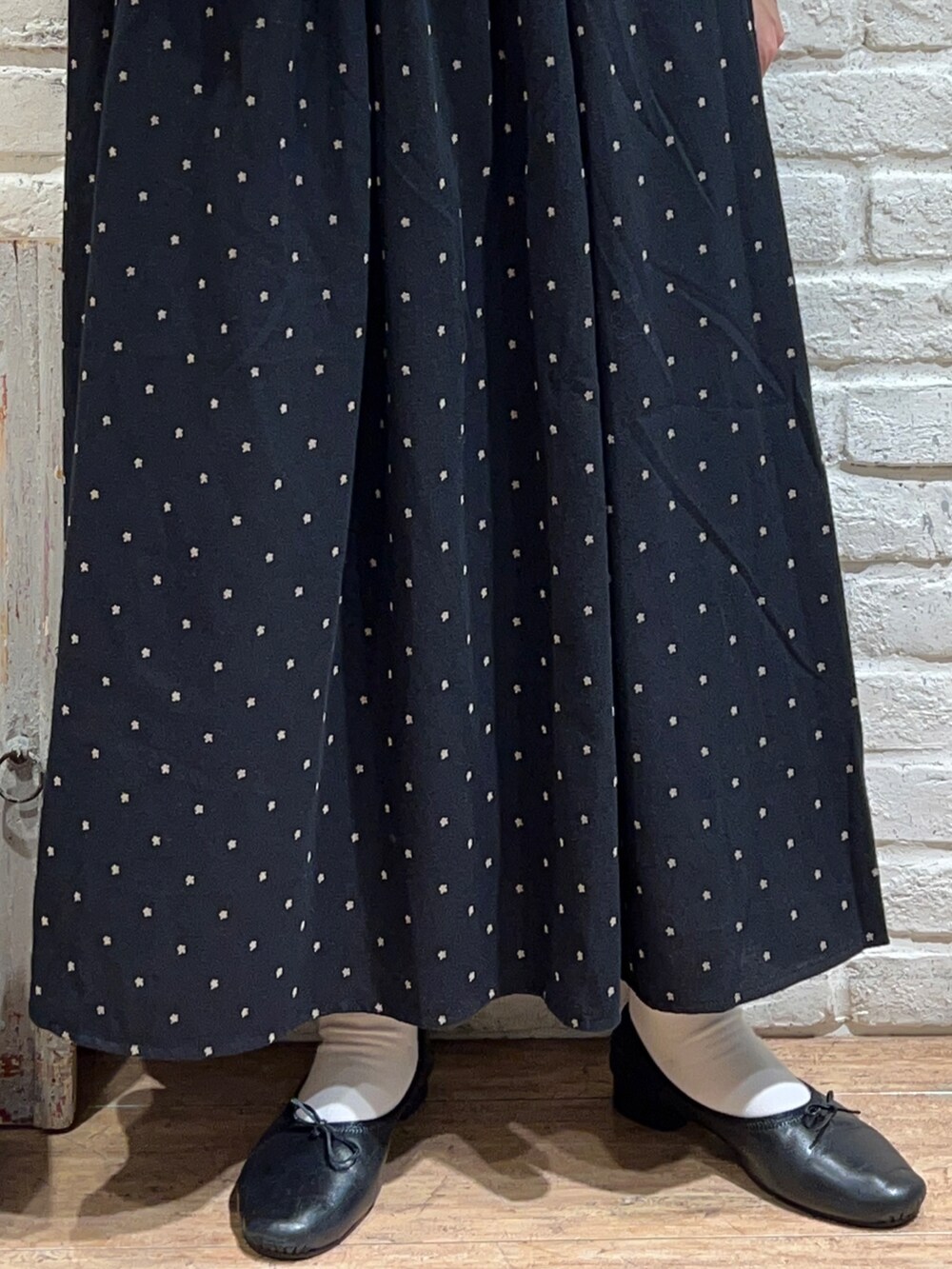 ブラック系のシャツ/ブラウス、ベージュ系のベスト、ブラック系のスカートを着用したレディースの秋コーディネートの4枚目の写真