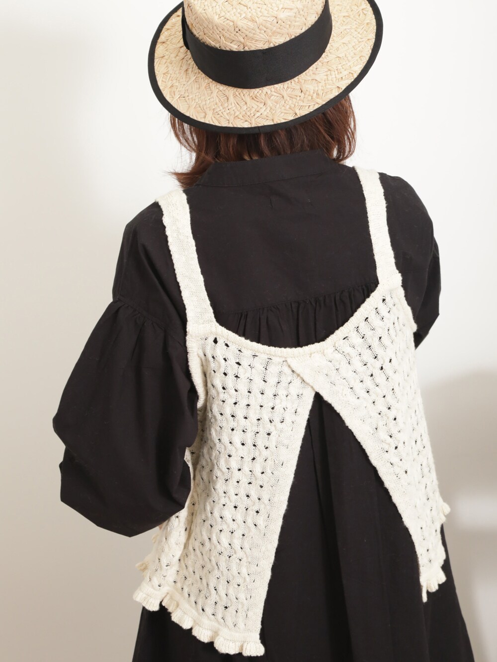 ホワイト系のベスト、ブラック系のワンピース、ブルー系のその他パンツを着用したレディースの春コーディネートの4枚目の写真