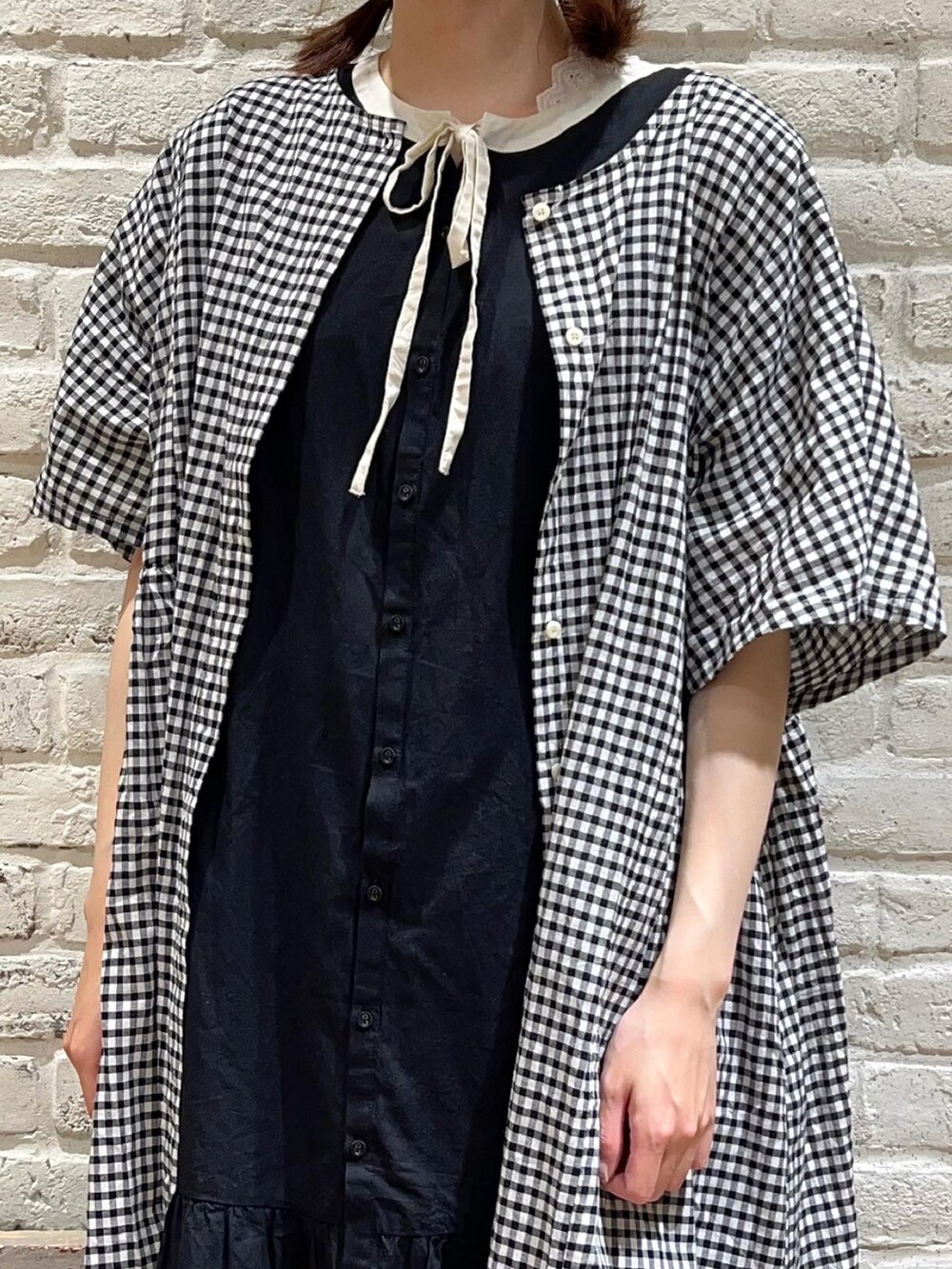 ホワイト系のタンクトップ、ブラック系のワンピース、ホワイト系のワンピースを着用したレディースの夏コーディネートの2枚目の写真