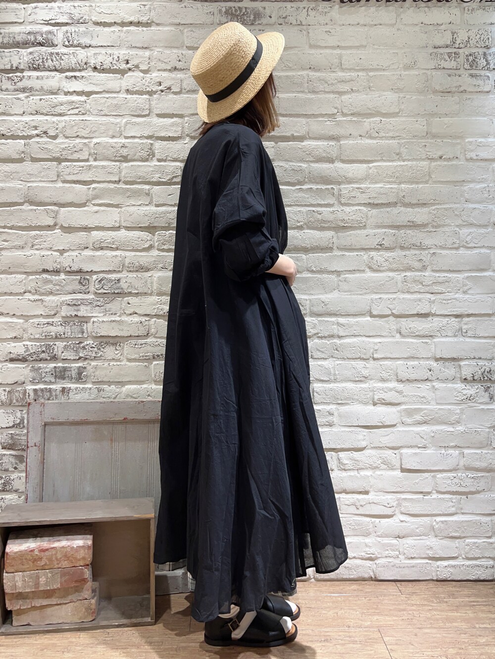 ベージュ系のTシャツ/カットソー、ブラック系のワンピース、グリーン系のスカートを着用したレディースの春コーディネートの3枚目の写真