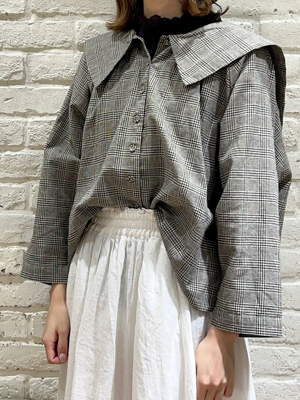 グレー系のTシャツ/カットソー、ブラック系のシャツ/ブラウス、ホワイト系のスカートを着用したレディースの春コーディネートの2枚目の写真