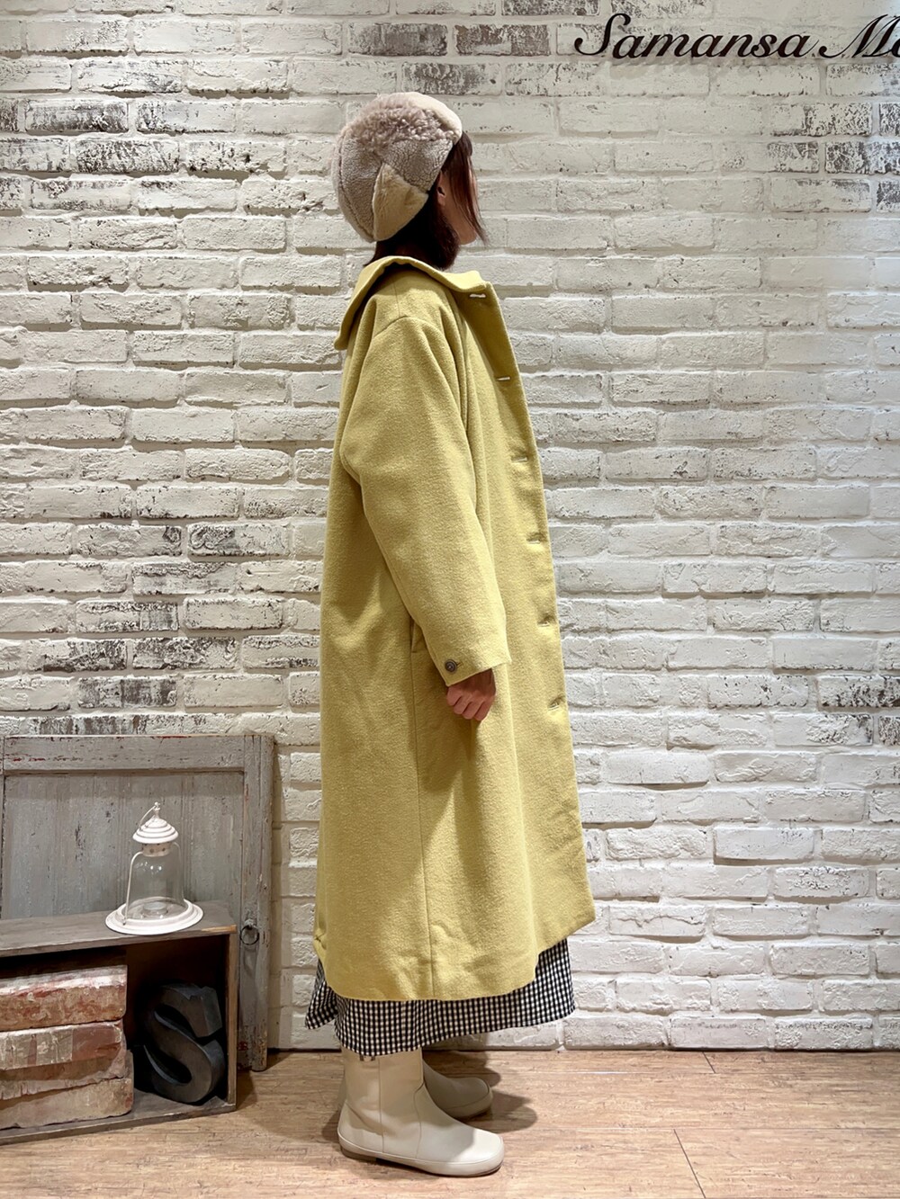 ベージュ系のチュニック、イエロー系のその他アウター、ホワイト系のブーツを着用したレディースの冬コーディネートの3枚目の写真