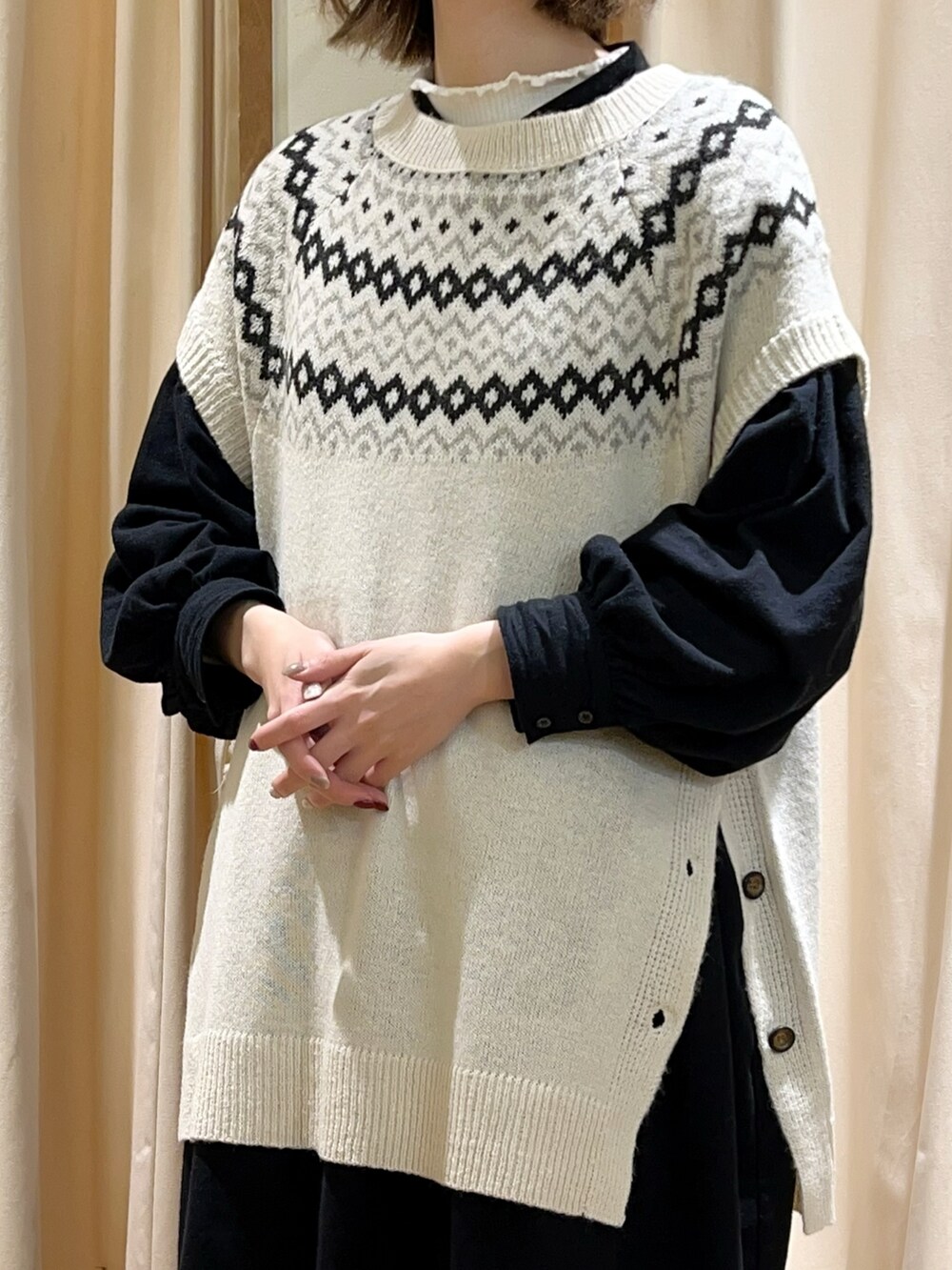 ホワイト系のTシャツ/カットソー、ホワイト系のベスト、ブラック系のワンピースを着用したレディースの冬コーディネートの2枚目の写真