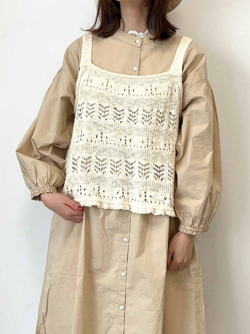 ホワイト系のベスト、ベージュ系のワンピース、ホワイト系のその他パンツを着用したレディースの春コーディネートの2枚目の写真