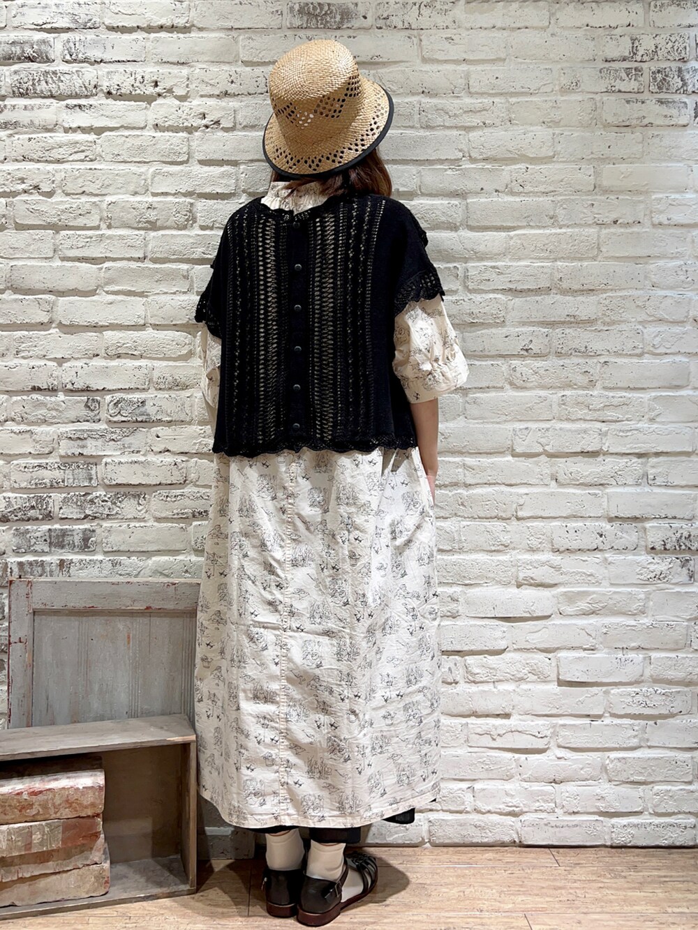 ブラック系のベスト、ブラック系のハンドバッグ、ホワイト系のワンピースを着用したレディースの夏コーディネートの4枚目の写真