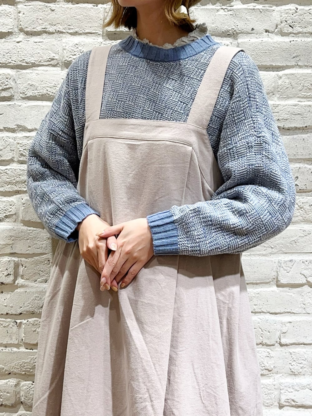 ホワイト系のシャツ/ブラウス、ブルー系のニット/セーター、ホワイト系のハンドバッグを着用したレディースの秋コーディネートの2枚目の写真