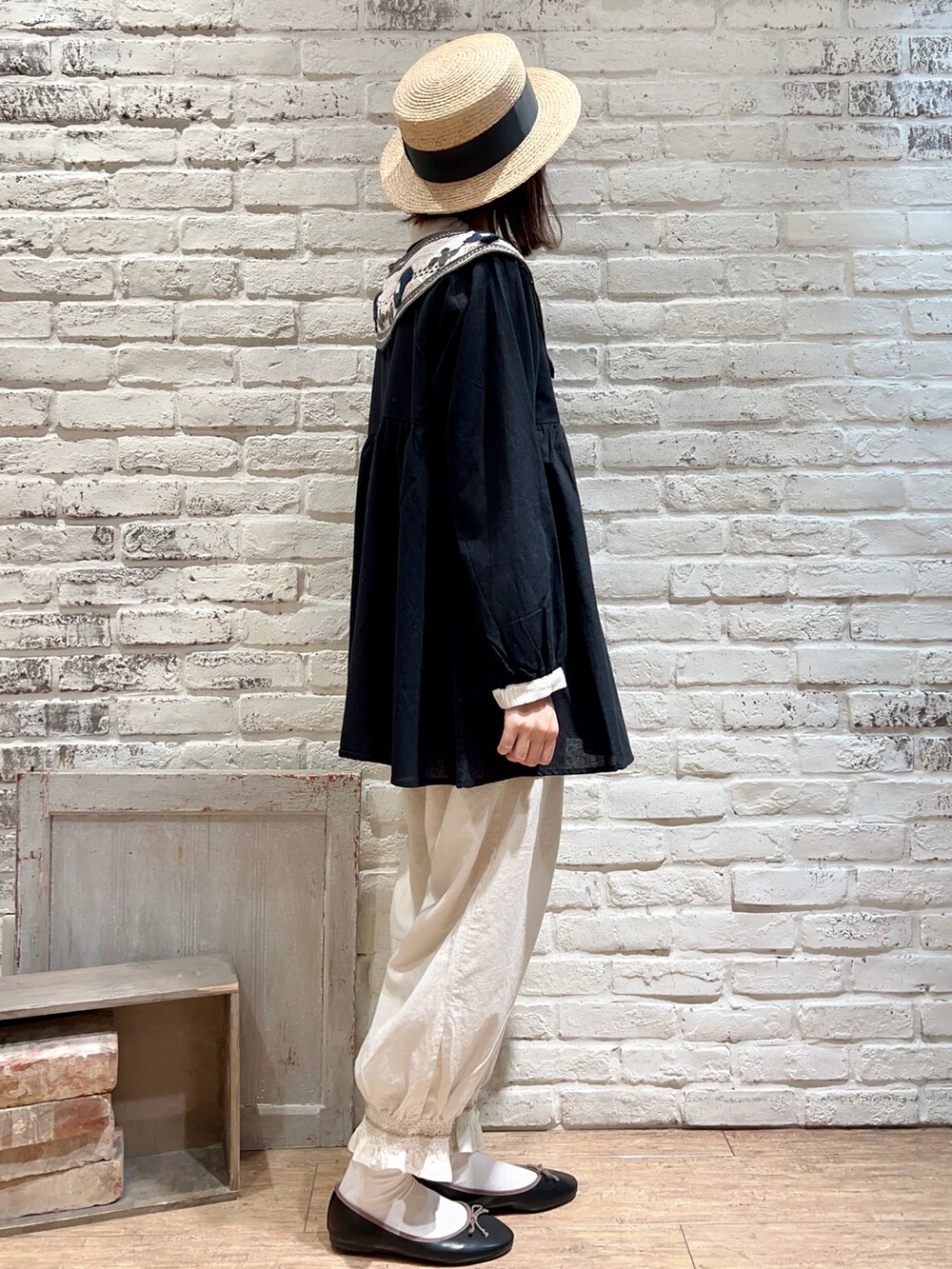 ブラック系のチュニック、ホワイト系のハンドバッグ、ホワイト系のその他パンツを着用したレディースの春コーディネートの3枚目の写真