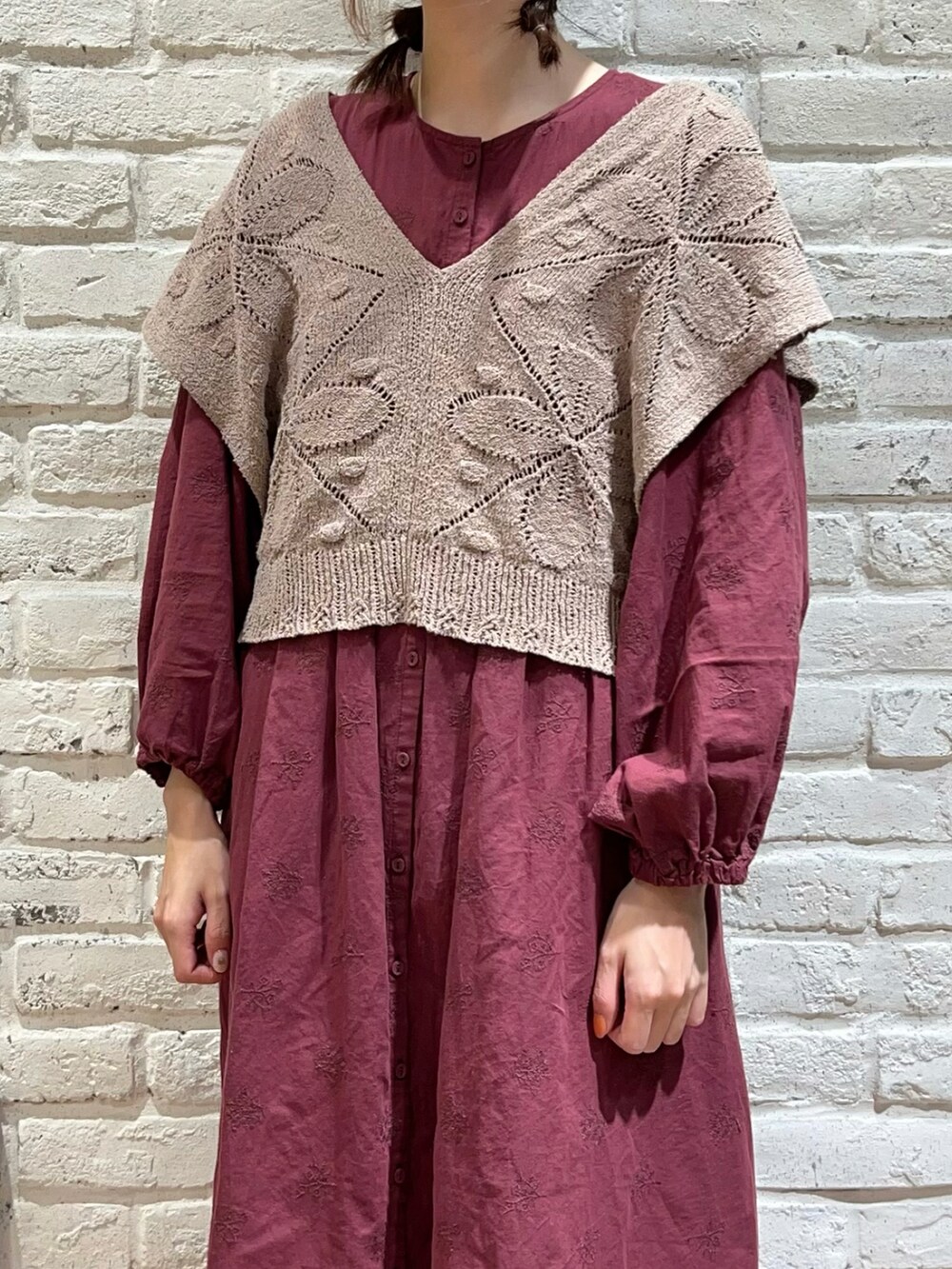 ベージュ系のベスト、レッド系のワンピース、グレー系のその他パンツを着用したレディースの秋コーディネートの2枚目の写真