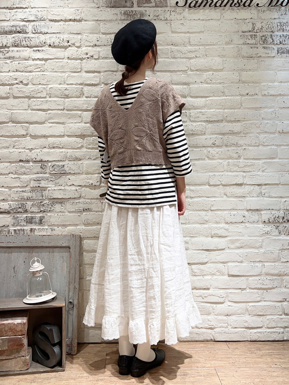 ホワイト系のTシャツ/カットソー、ベージュ系のベスト、ブラック系のハットを着用したレディースの秋コーディネートの5枚目の写真