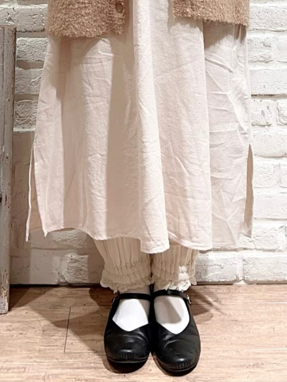 ホワイト系のニット/セーター、ホワイト系のワンピース、ベージュ系のカーディガン/ボレロを着用したレディースの冬コーディネートの4枚目の写真