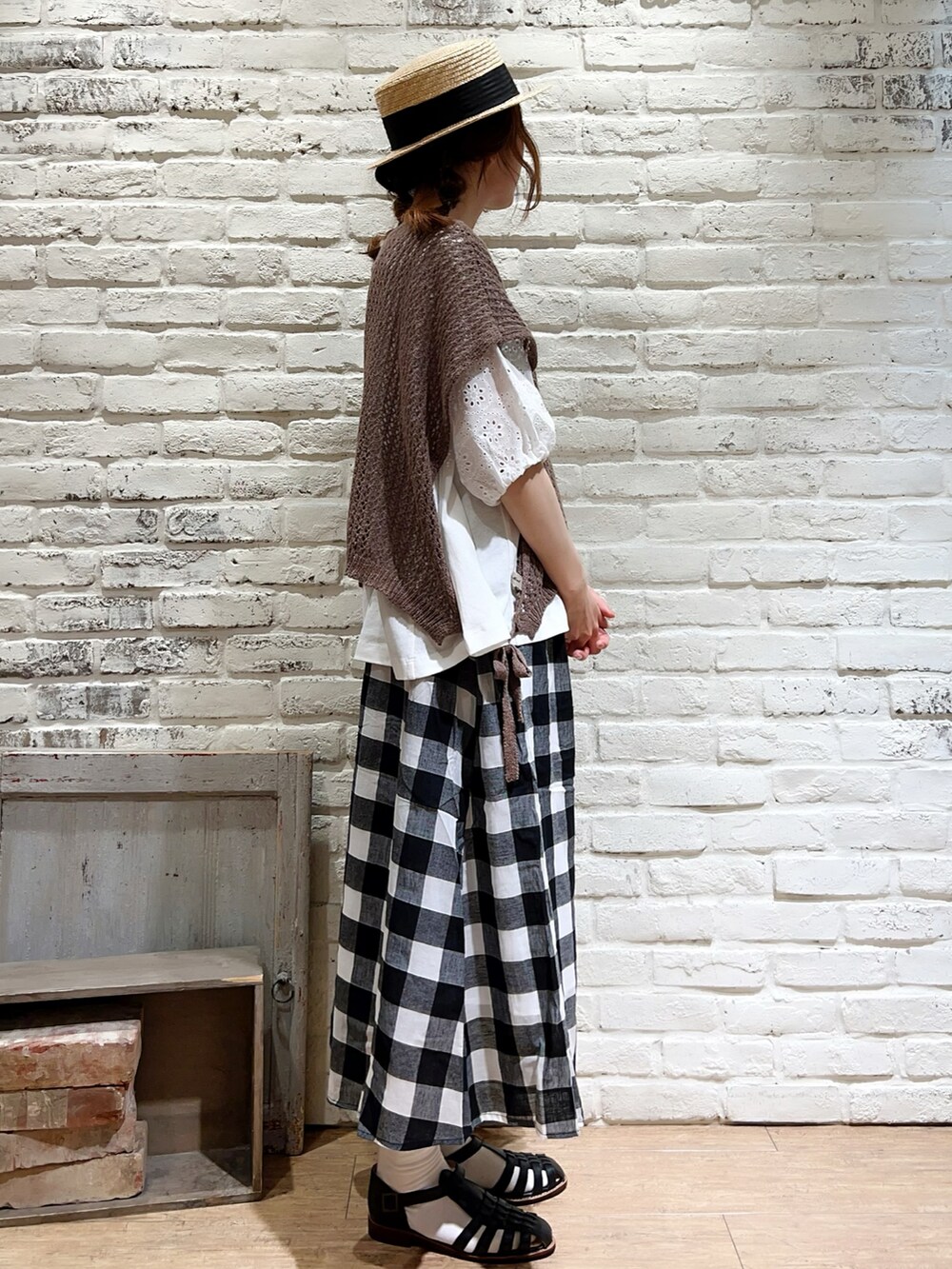 ホワイト系のTシャツ/カットソー、ブラウン系のベスト、ホワイト系のニット/セーターを着用したレディースの夏コーディネートの2枚目の写真