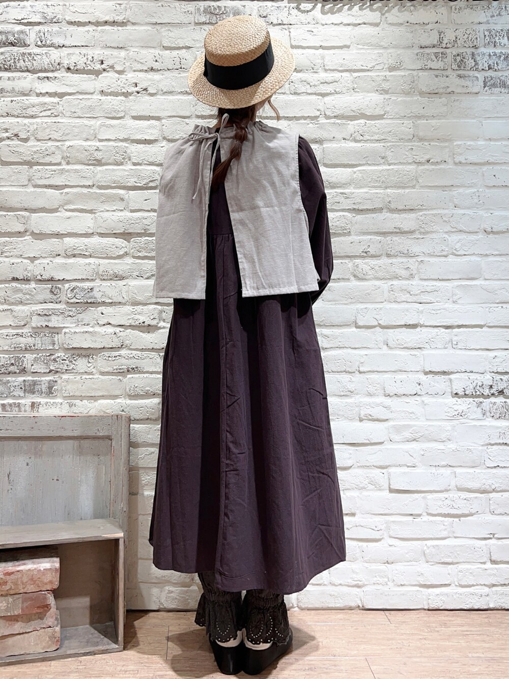 グレー系のベスト、ブラック系のTシャツ/カットソー、ブラック系のワンピースを着用したレディースの春コーディネートの4枚目の写真