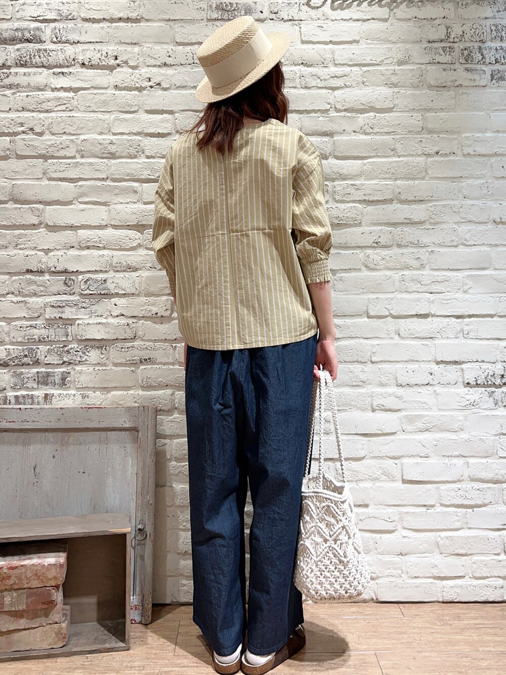ホワイト系のTシャツ/カットソー、イエロー系のシャツ/ブラウス、ブルー系のデニムパンツを着用したレディースの春コーディネートの4枚目の写真
