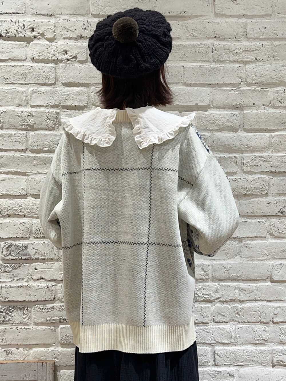 ホワイト系のシャツ/ブラウス、ホワイト系のニット/セーター、ブラック系のスカートを着用したレディースの冬コーディネートの4枚目の写真