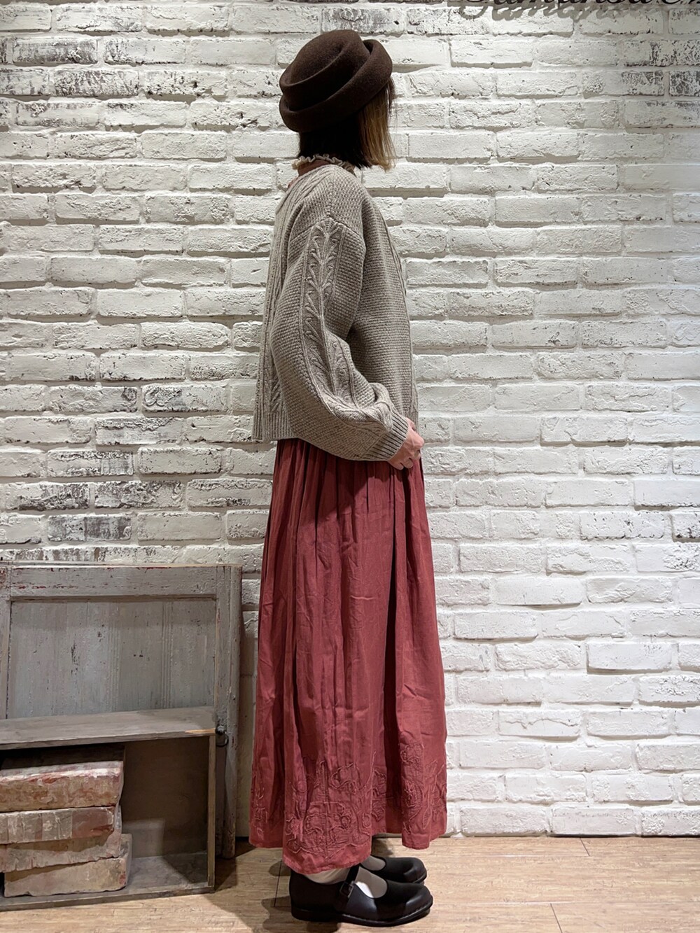 ホワイト系のニット/セーター、ベージュ系のカーディガン/ボレロ、ベージュ系のスカートを着用したレディースの秋コーディネートの4枚目の写真