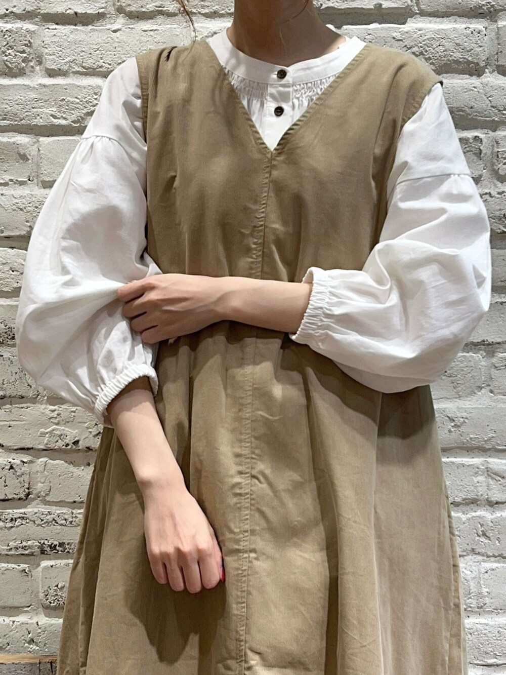 ホワイト系のシャツ/ブラウス、ブラック系のカーディガン/ボレロ、ベージュ系のジャンパースカートを着用したレディースの秋コーディネートの3枚目の写真