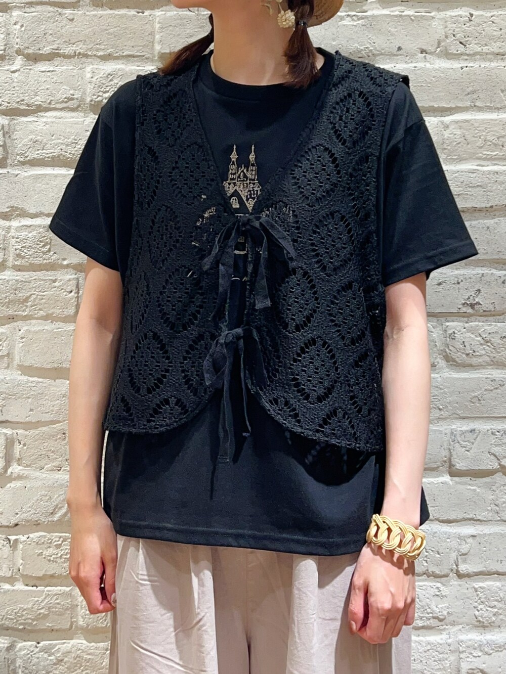 ブラック系のTシャツ/カットソー、ブラック系のベスト、ブラウン系のハンドバッグを着用したレディースの秋コーディネートの2枚目の写真