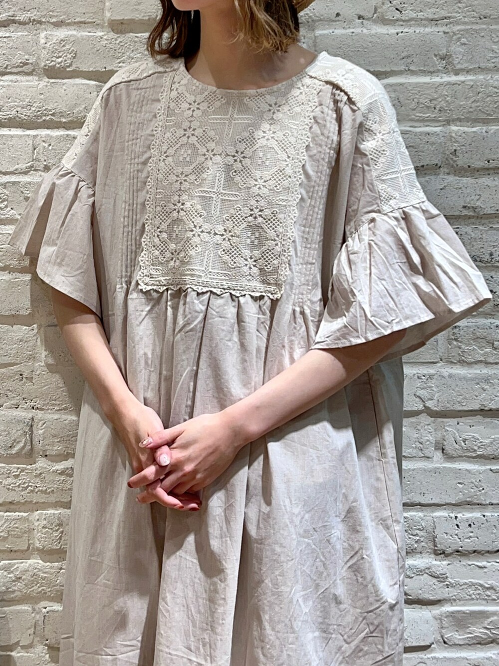 ホワイト系のワンピース、ホワイト系のハンドバッグ、ベージュ系のその他パンツを着用したレディースの春コーディネートの2枚目の写真