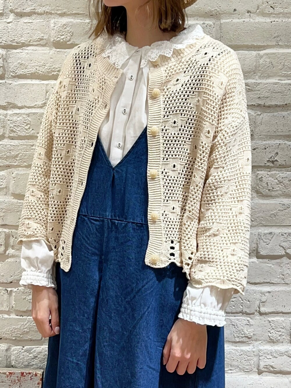 ホワイト系のシャツ/ブラウス、ホワイト系のカーディガン/ボレロ、ホワイト系のハンドバッグを着用したレディースの春コーディネートの2枚目の写真