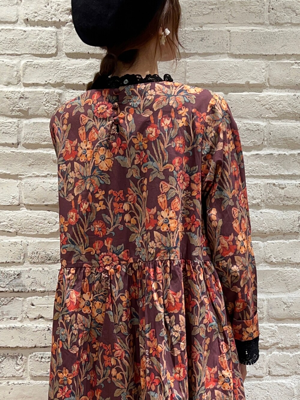 ブラック系のTシャツ/カットソー、ブラック系のベスト、ブラウン系のワンピースを着用したレディースの秋コーディネートの4枚目の写真