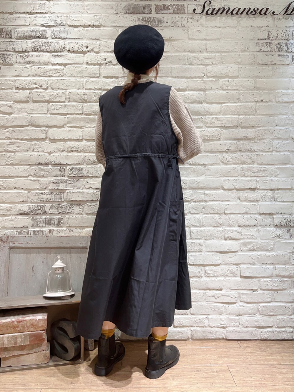 ホワイト系のニット/セーター、ブラック系のワンピース、ブラック系のブーツを着用したレディースの冬コーディネートの5枚目の写真