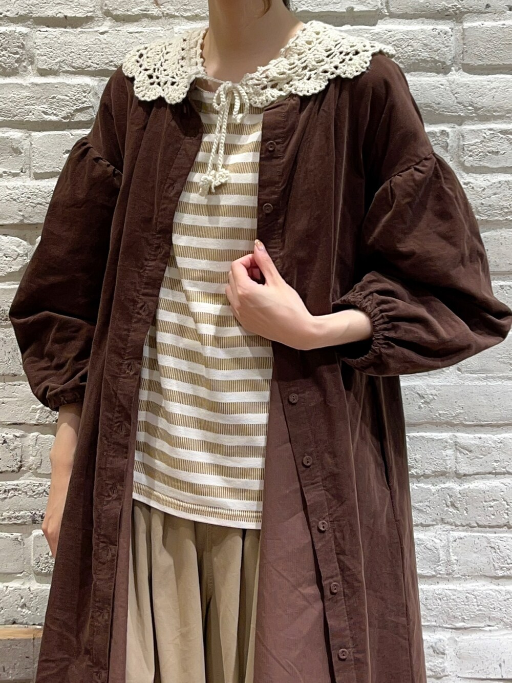 イエロー系のTシャツ/カットソー、ブラウン系のワンピース、ベージュ系のその他パンツを着用したレディースの秋コーディネートの2枚目の写真