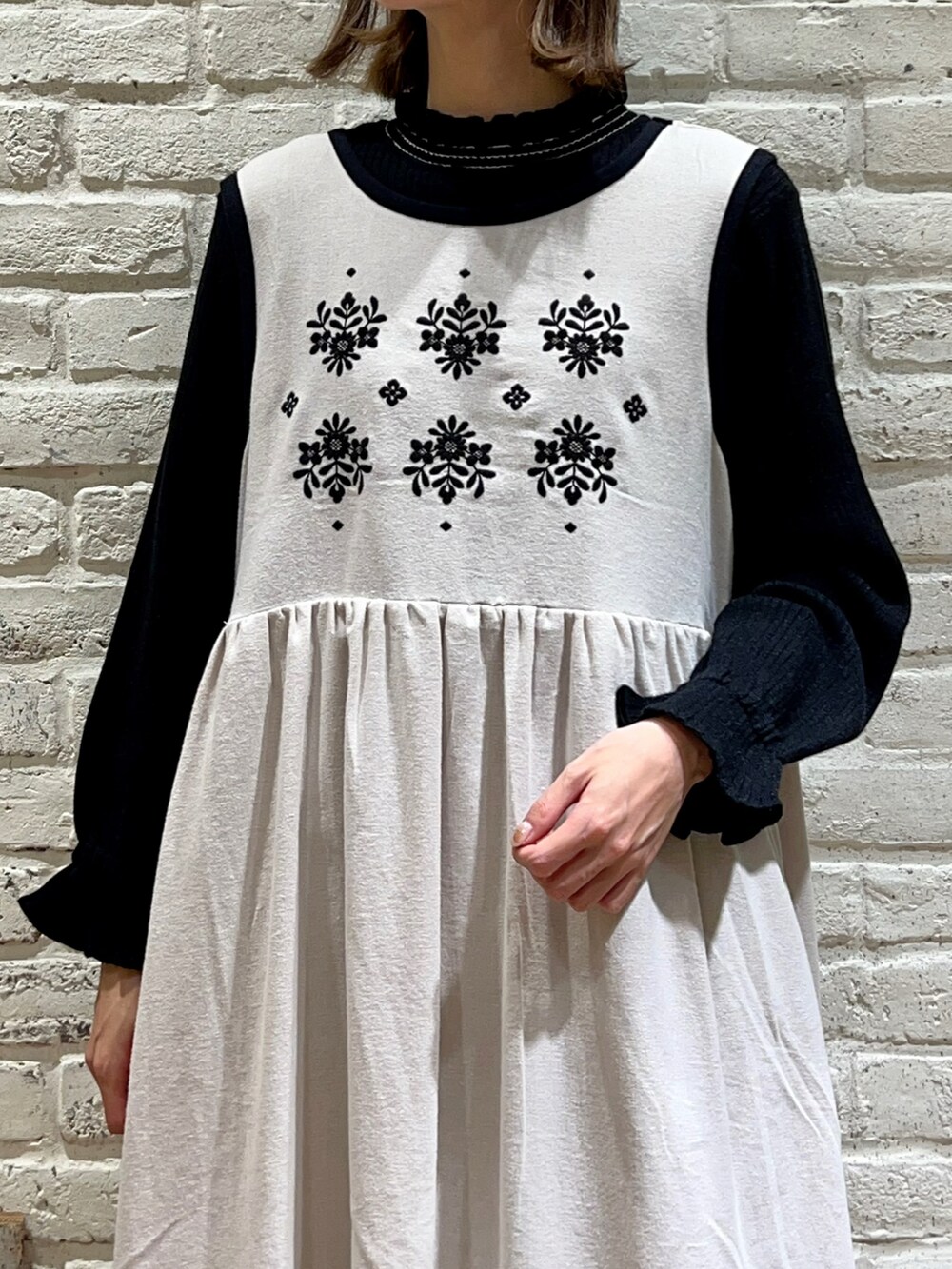 ブラック系のニット/セーター、ホワイト系のワンピース、ブルー系のカーディガン/ボレロを着用したレディースの冬コーディネートの3枚目の写真