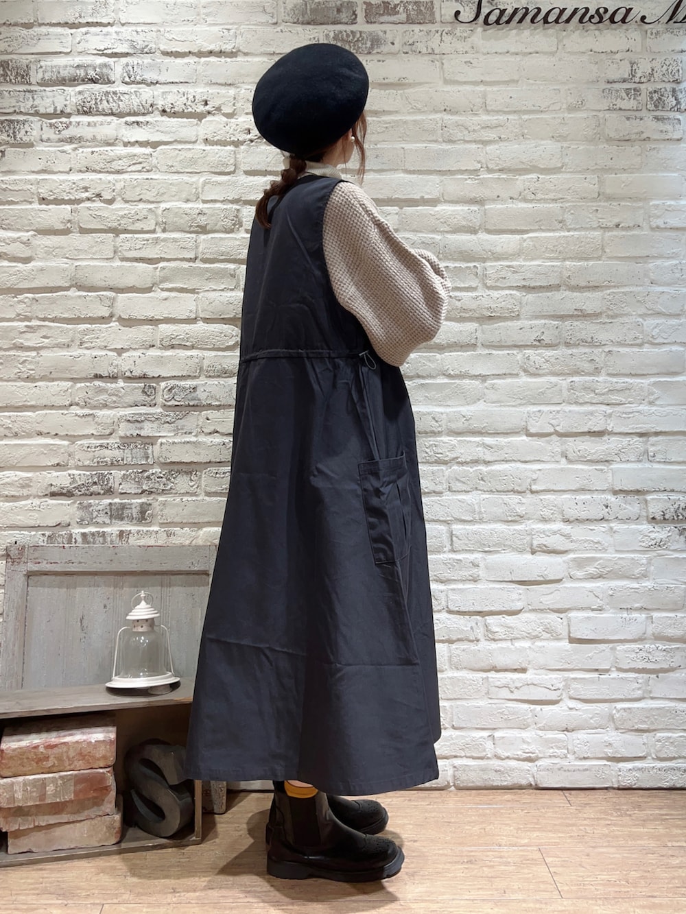 ホワイト系のニット/セーター、ブラック系のワンピース、ブラック系のブーツを着用したレディースの冬コーディネートの4枚目の写真