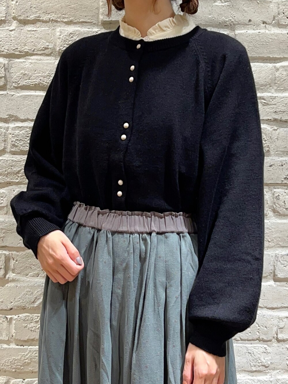 ホワイト系のシャツ/ブラウス、ブラック系のカーディガン/ボレロ、グリーン系のスカートを着用したレディースの秋コーディネートの2枚目の写真