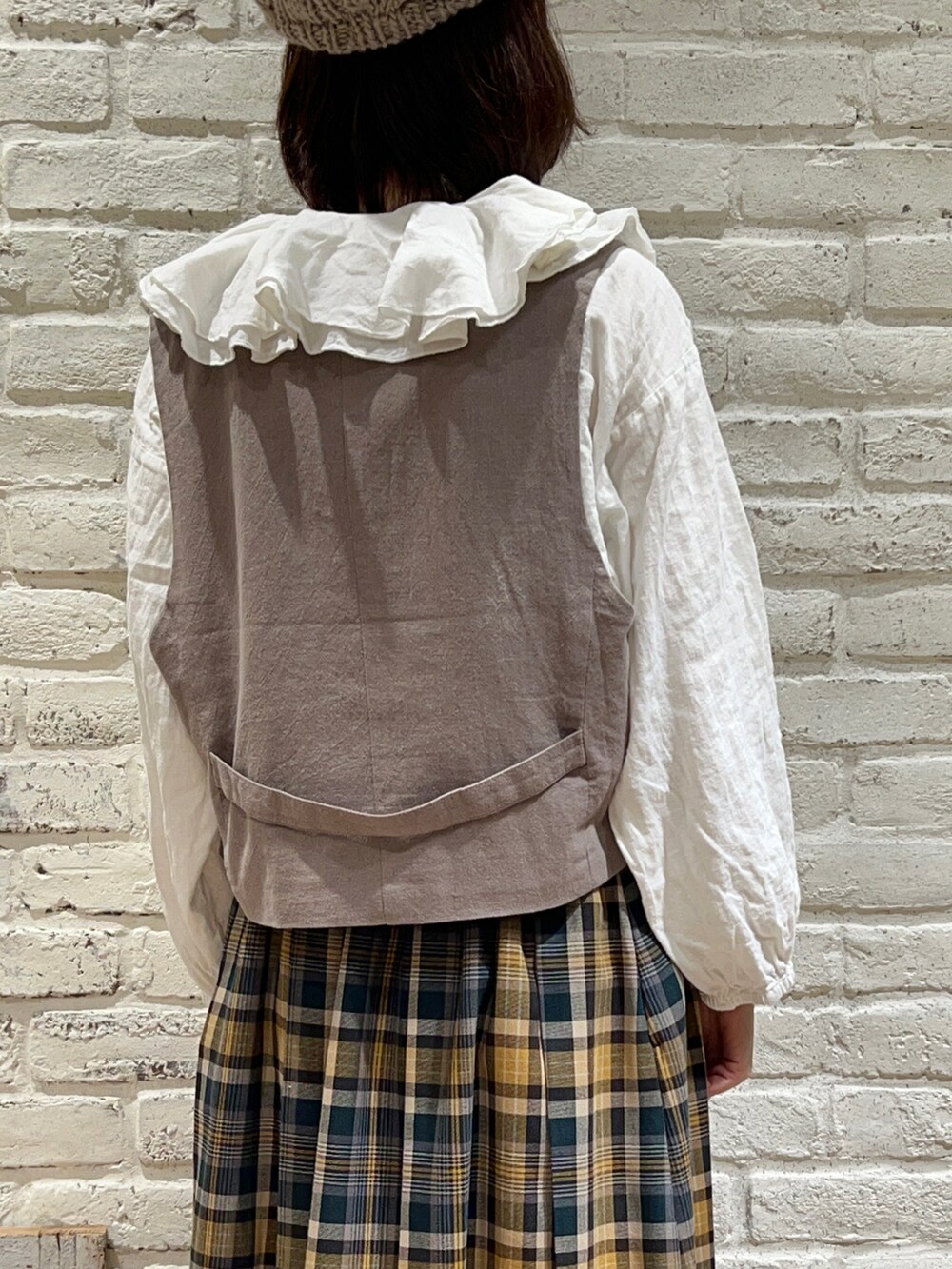 ホワイト系のシャツ/ブラウス、ブラウン系のベスト、ベージュ系のその他アウターを着用したレディースの冬コーディネートの5枚目の写真