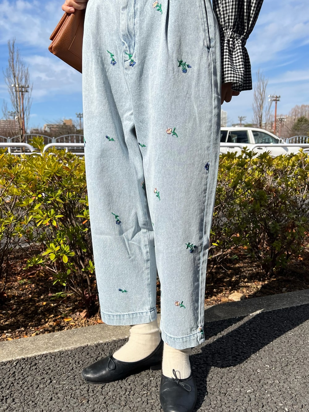 ブラック系のシャツ/ブラウス、ホワイト系のニット/セーター、ブルー系のデニムパンツを着用したレディースの冬コーディネートの4枚目の写真