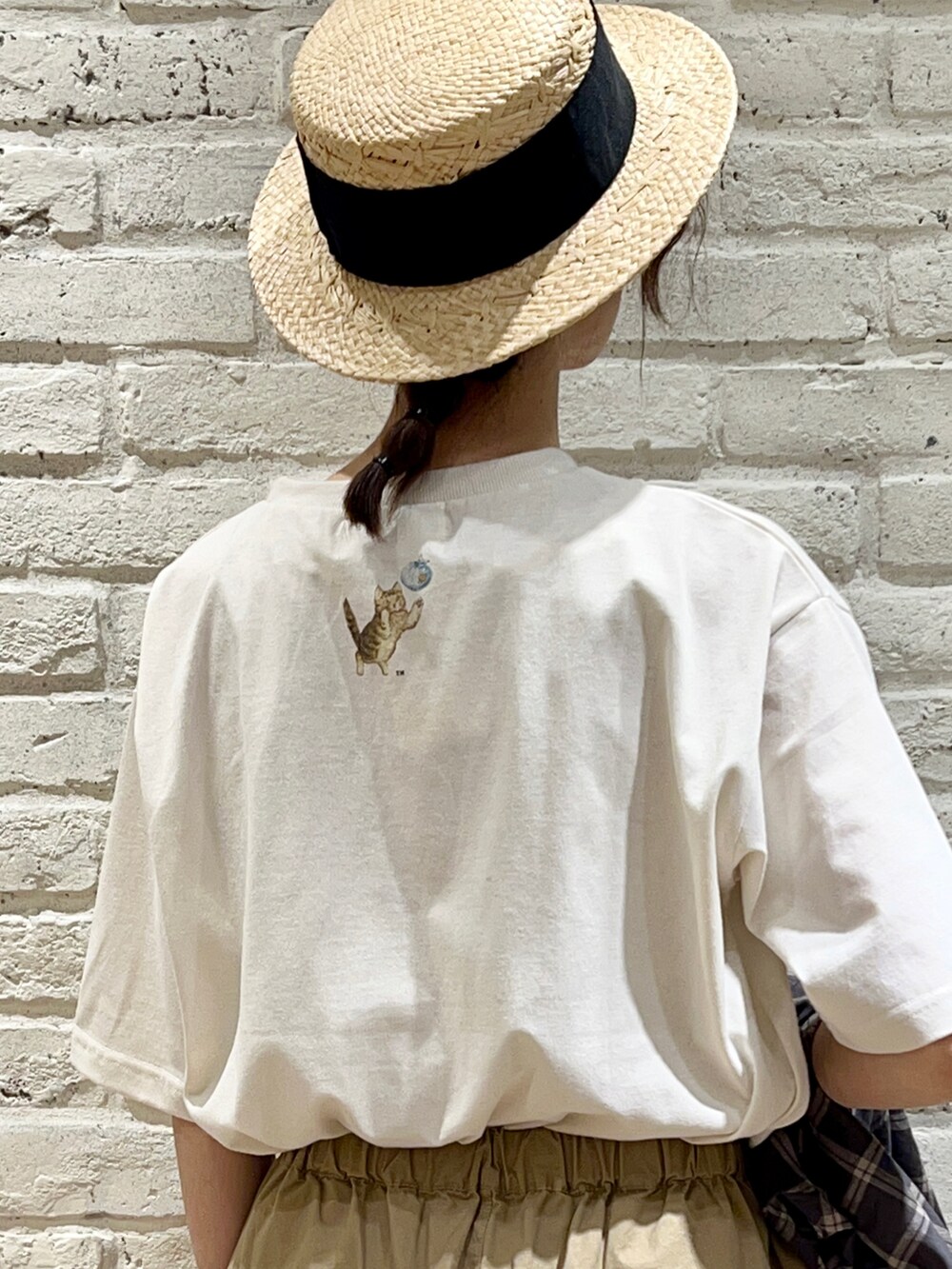 ホワイト系のTシャツ/カットソー、ブラウン系のチュニック、ブラック系のハンドバッグを着用したレディースの夏コーディネートの5枚目の写真