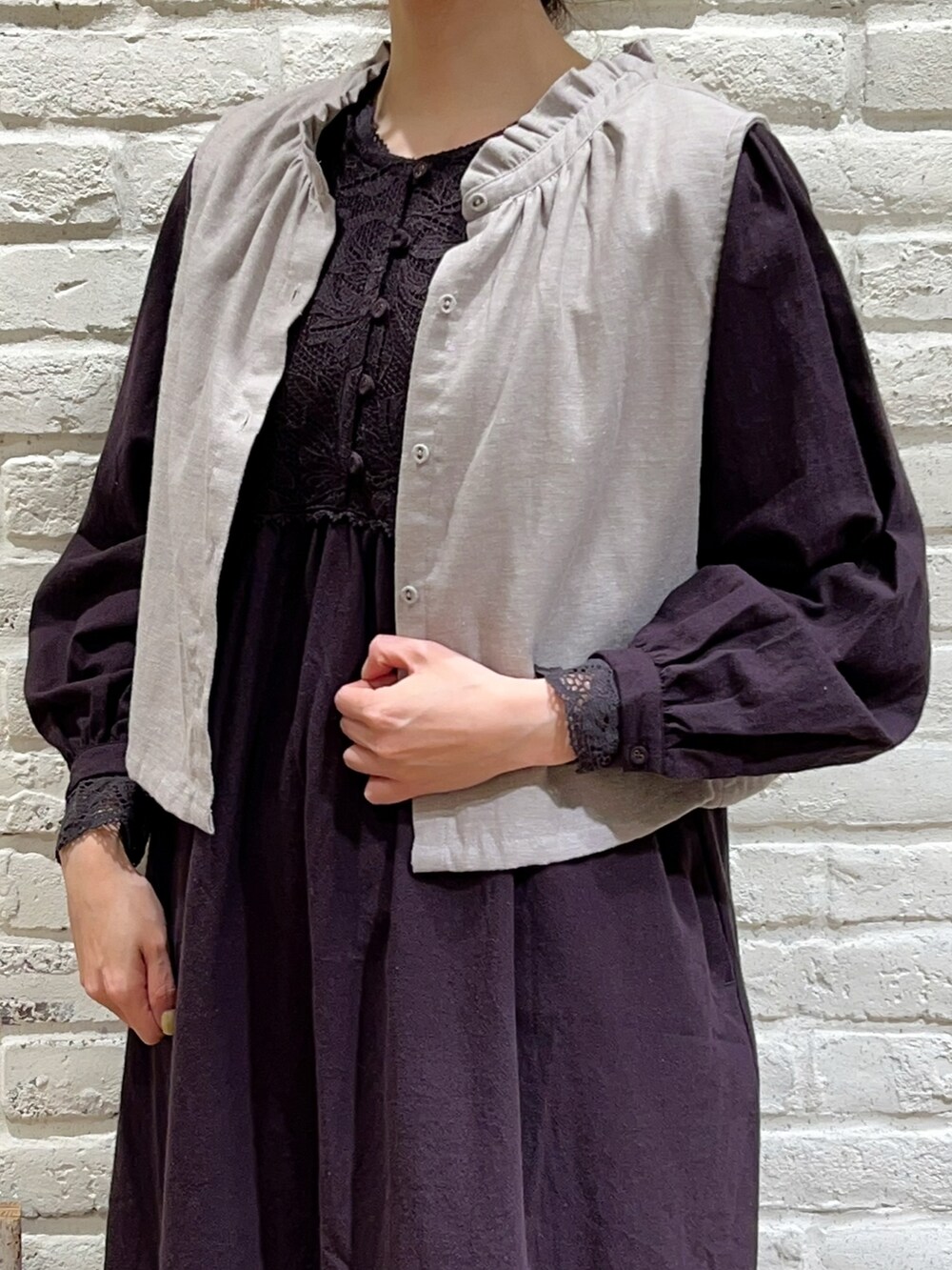 グレー系のベスト、ブラック系のTシャツ/カットソー、ブラック系のワンピースを着用したレディースの春コーディネートの2枚目の写真