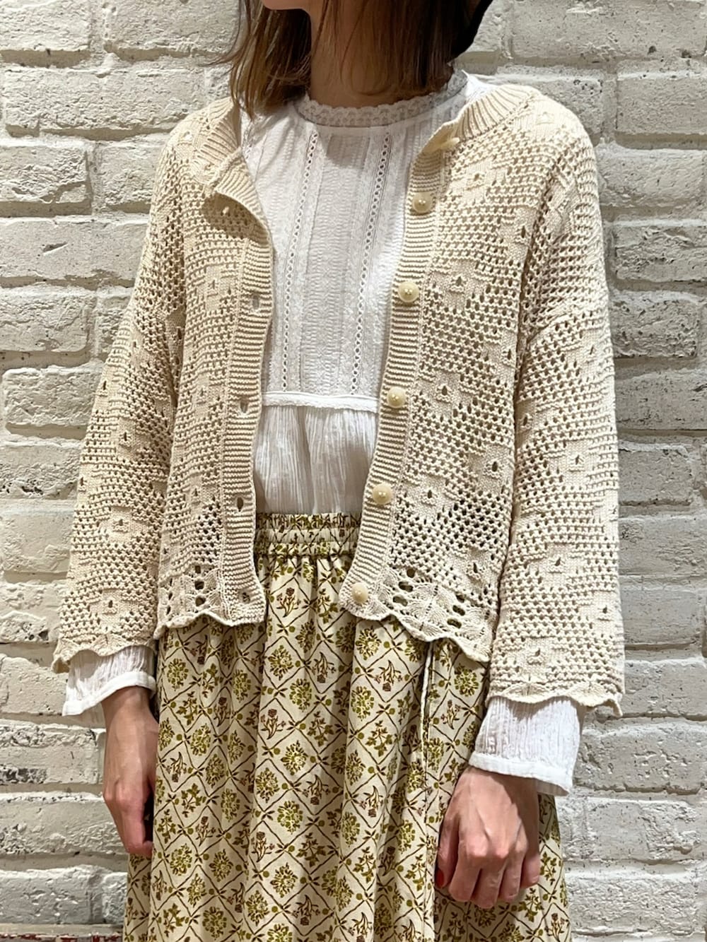 ホワイト系のシャツ/ブラウス、ホワイト系のカーディガン/ボレロ、ベージュ系のスカートを着用したレディースの春コーディネートの2枚目の写真
