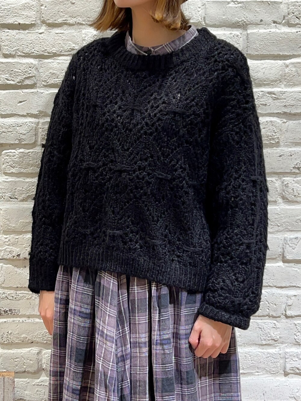 ブラック系のシャツ/ブラウス、ブラック系のニット/セーター、ブラック系のスカートを着用したレディースの冬コーディネートの2枚目の写真