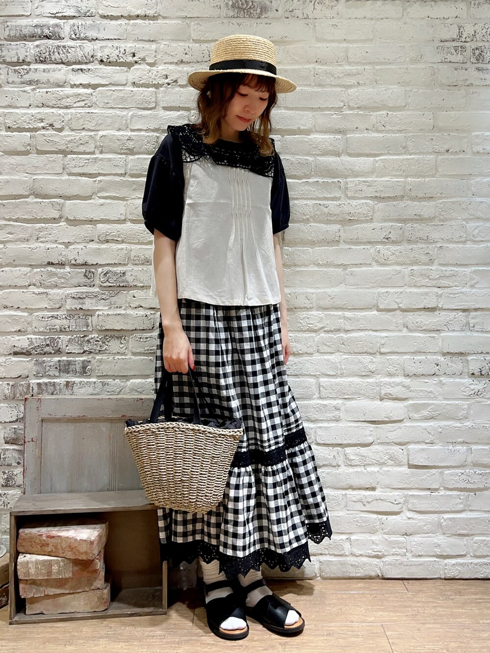 グレー系のTシャツ/カットソー、ホワイト系のベスト、ブラック系のスカートを着用したレディースの秋コーディネートの3枚目の写真