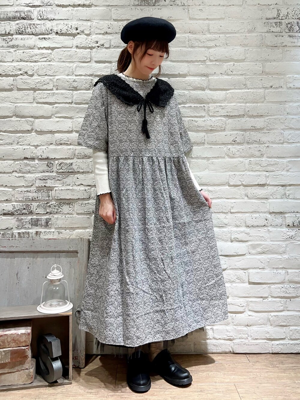 ホワイト系のTシャツ/カットソー、グレー系のワンピース、ブラック系のスカートを着用したレディースの秋コーディネートの3枚目の写真