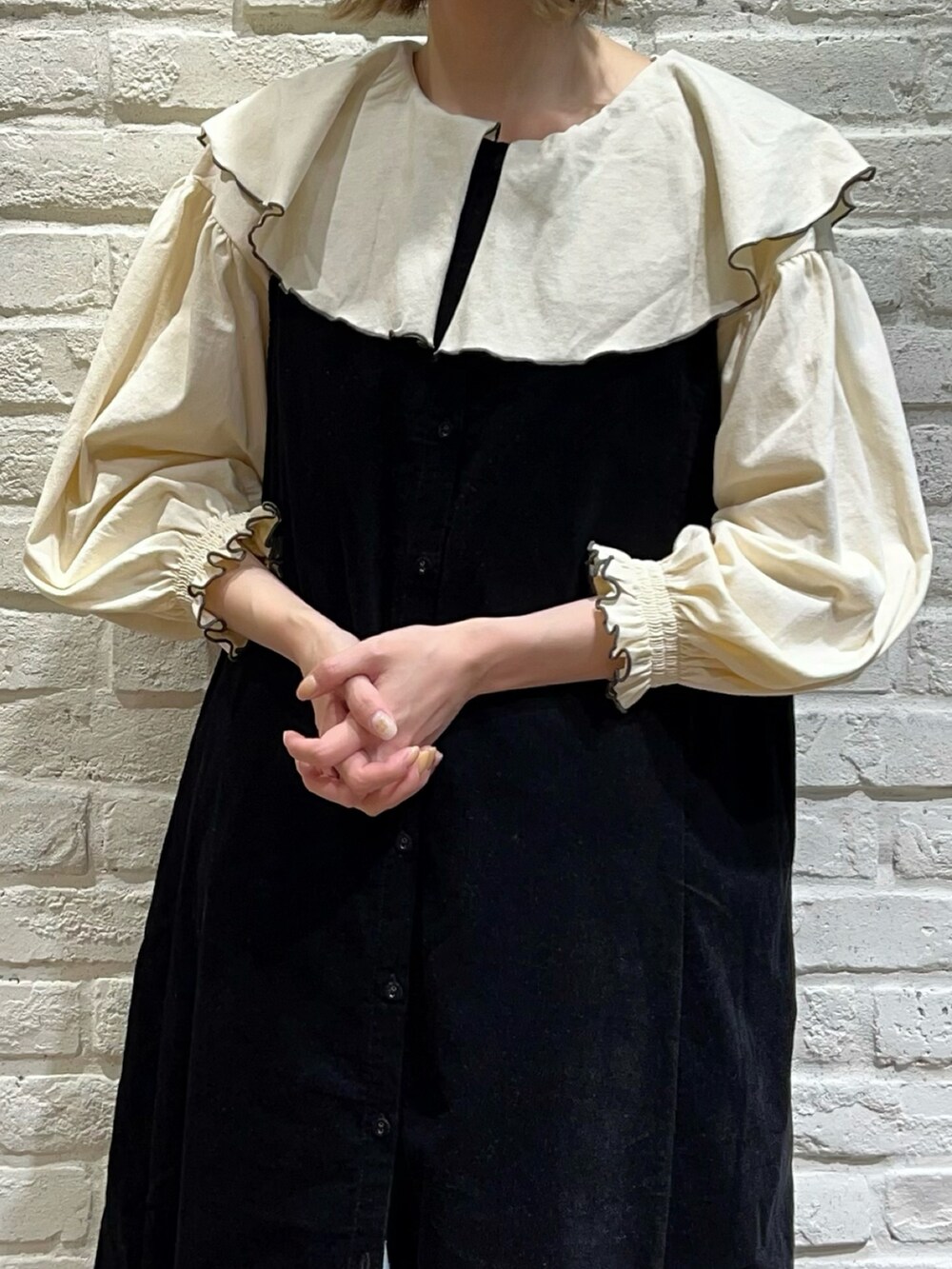 グレー系のTシャツ/カットソー、ブラック系のジャンパースカート、ブルー系のスカートを着用したレディースの秋コーディネートの2枚目の写真