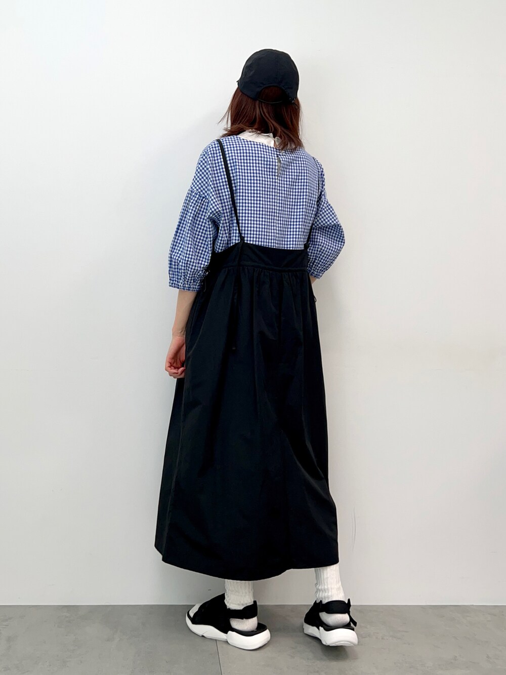ホワイト系のTシャツ/カットソー、ブラック系のワンピース、ブラック系のサンダルを着用したレディースの春コーディネートの4枚目の写真