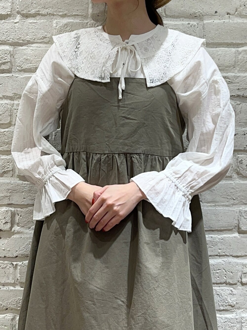 ホワイト系のシャツ/ブラウス、グリーン系のワンピース、ブラック系のハンドバッグを着用したレディースの夏コーディネートの2枚目の写真